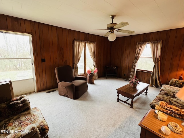 living room featuring ceiling fan, light carpet, and a wealth of natural light