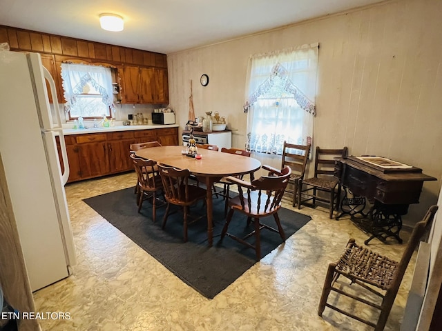 dining space featuring wood walls