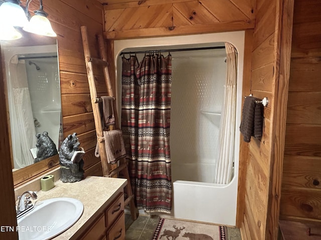 bathroom with tile patterned floors, wooden walls, shower / tub combo with curtain, and vanity