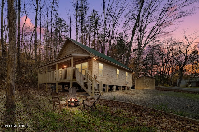 exterior space with a fire pit, a storage unit, and a deck