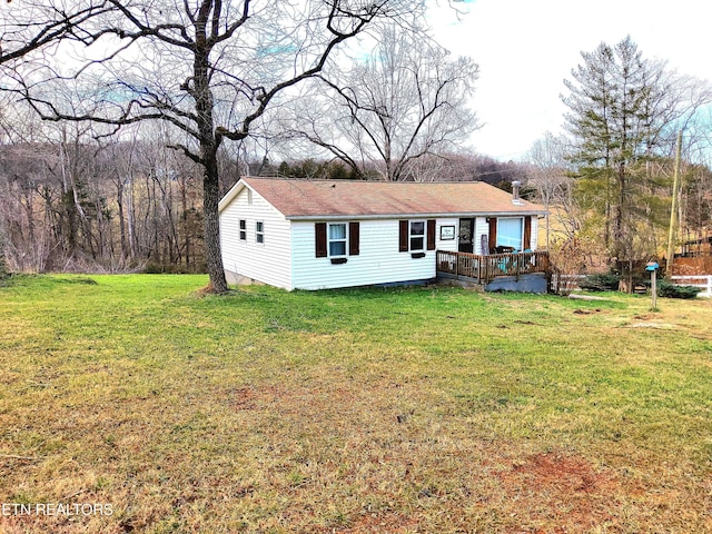 view of front facade with a deck and a front lawn