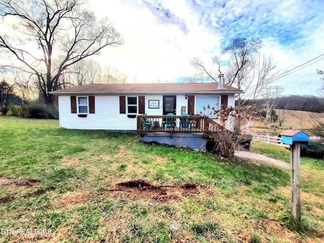 ranch-style house with a front lawn and a wooden deck