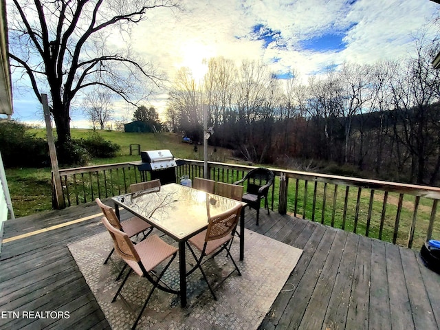 wooden terrace with a grill and a yard