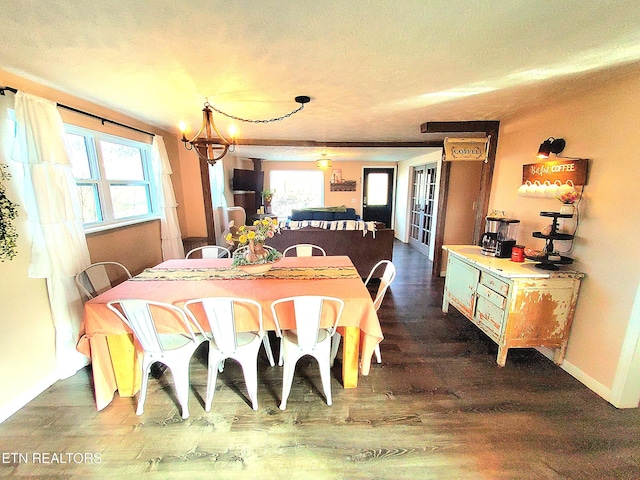 dining space featuring a notable chandelier, a healthy amount of sunlight, dark hardwood / wood-style flooring, and a textured ceiling