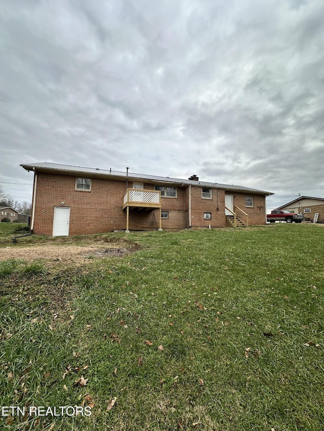 rear view of house featuring a yard