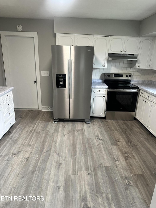 kitchen with light wood-type flooring, white cabinetry, stainless steel appliances, and tasteful backsplash