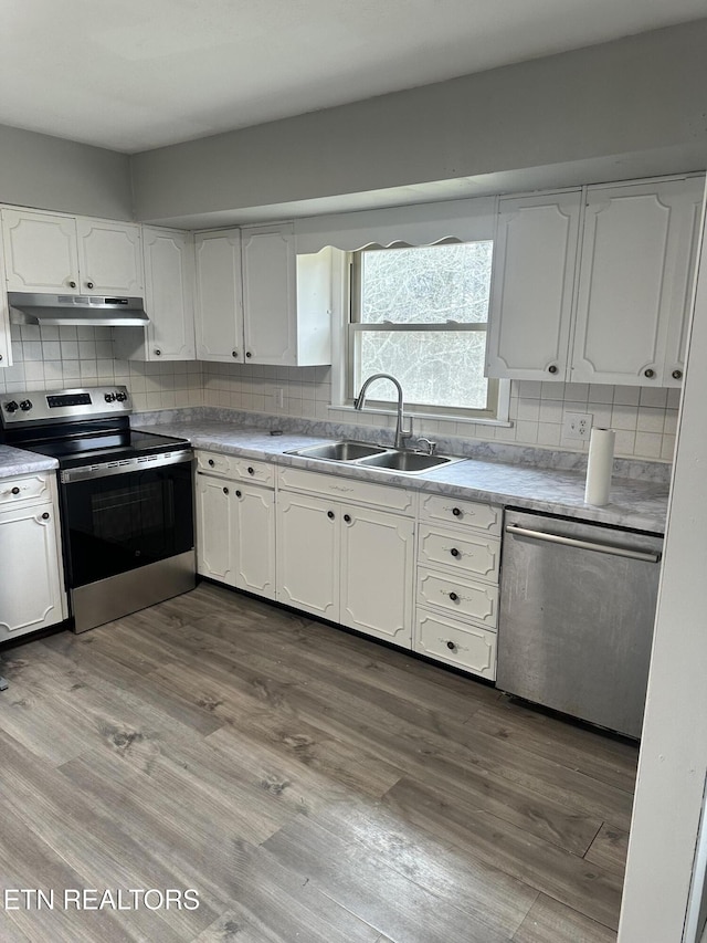 kitchen featuring white cabinets, light wood-type flooring, stainless steel appliances, and sink