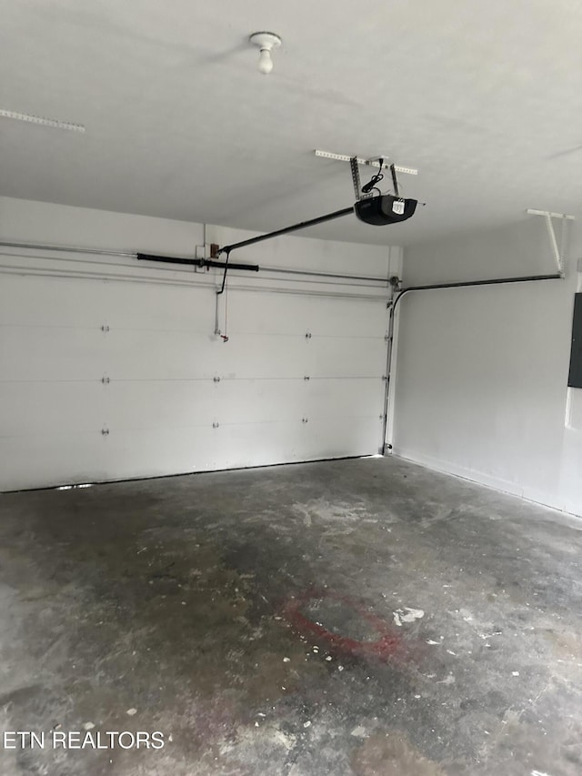 garage featuring electric panel and a garage door opener