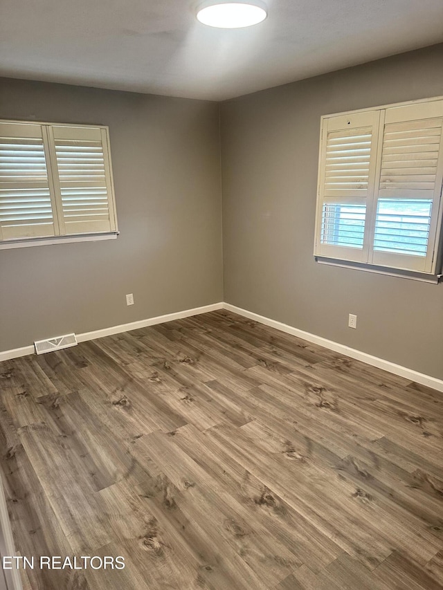 spare room featuring wood-type flooring