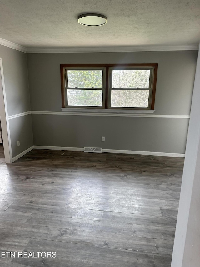 empty room with crown molding and hardwood / wood-style floors