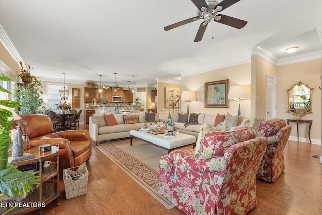 living room with hardwood / wood-style flooring, crown molding, and ceiling fan