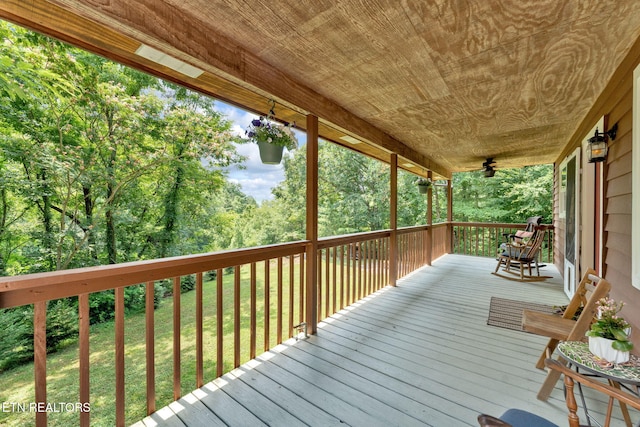 deck with ceiling fan and a yard