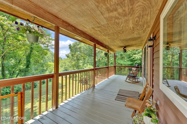 wooden terrace with ceiling fan and a porch