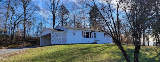 view of home's exterior featuring a carport and a lawn