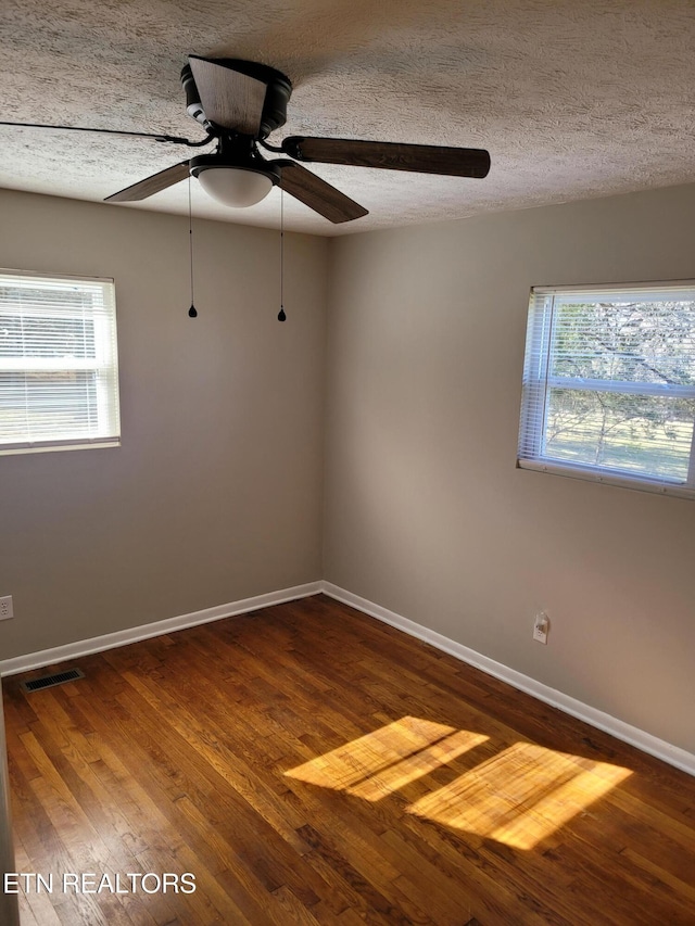 unfurnished room featuring ceiling fan, wood-type flooring, and a textured ceiling