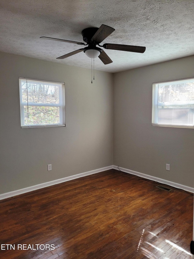 empty room featuring dark hardwood / wood-style flooring and a textured ceiling