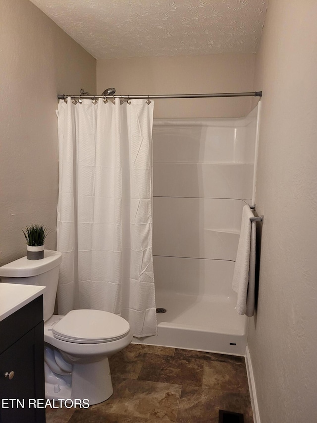 bathroom featuring vanity, curtained shower, a textured ceiling, and toilet