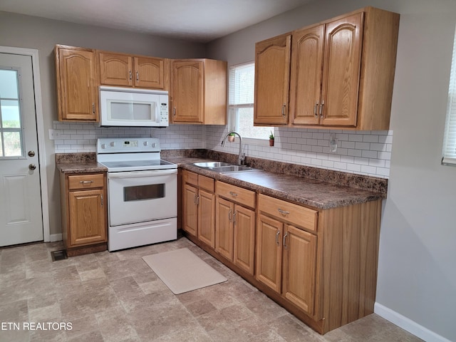 kitchen featuring sink, backsplash, and white appliances