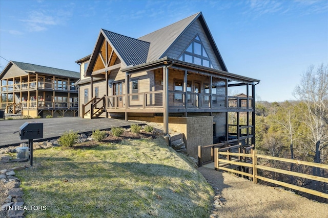 view of side of home with a balcony, a yard, and a wooden deck