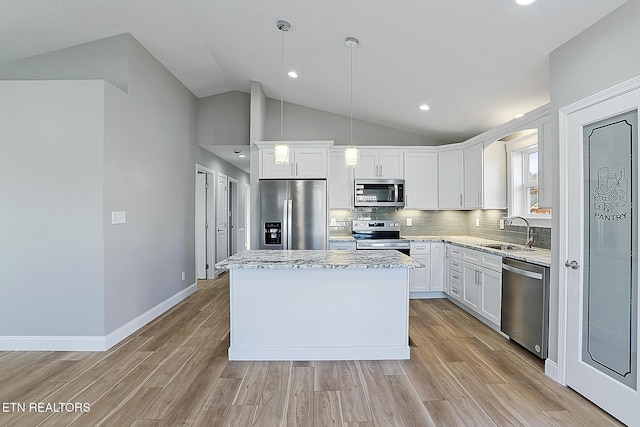 kitchen featuring appliances with stainless steel finishes, sink, pendant lighting, a center island, and white cabinetry