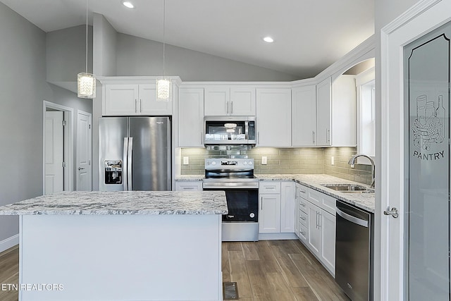 kitchen with white cabinetry, sink, stainless steel appliances, and decorative light fixtures