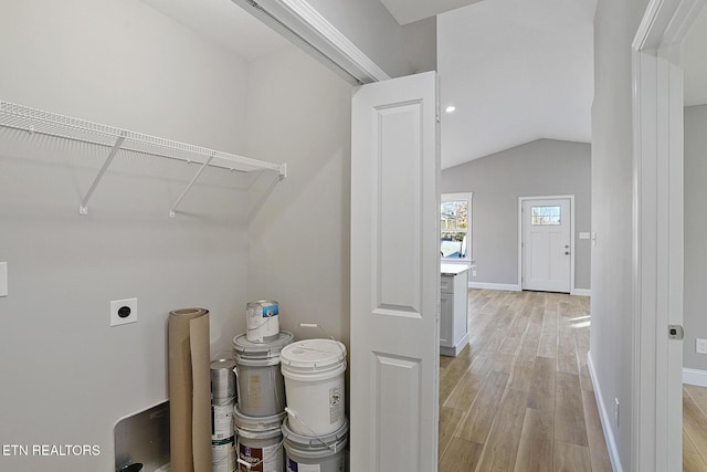 clothes washing area with electric dryer hookup and light hardwood / wood-style flooring