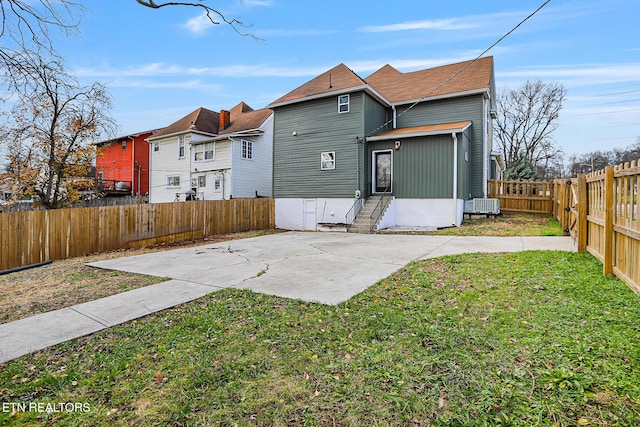 back of house with central AC, a yard, and a patio