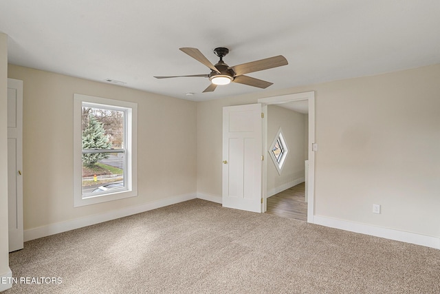 carpeted spare room featuring ceiling fan