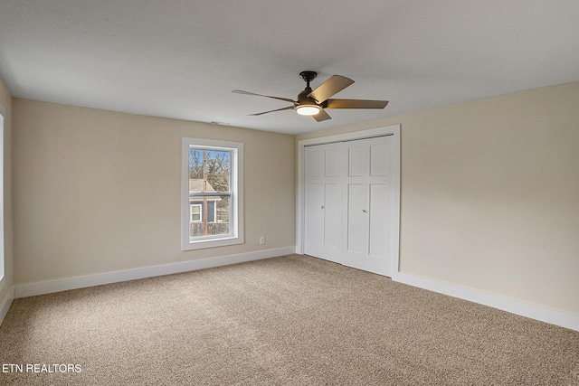 unfurnished bedroom featuring carpet flooring, ceiling fan, and a closet