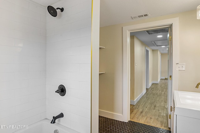 bathroom featuring vanity, tiled shower / bath combo, and hardwood / wood-style flooring