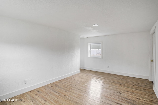 empty room featuring a textured ceiling and hardwood / wood-style flooring