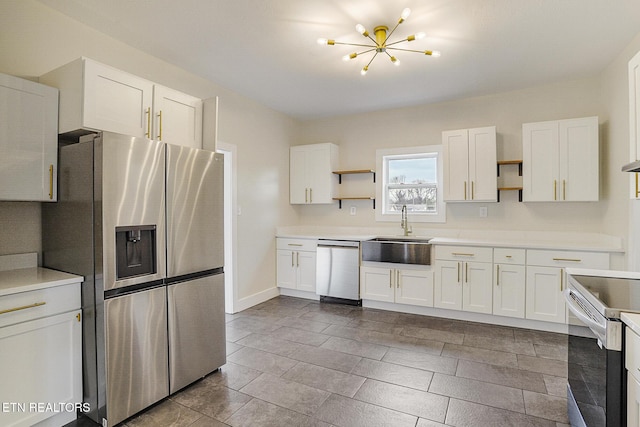 kitchen with white cabinetry, sink, appliances with stainless steel finishes, and a chandelier