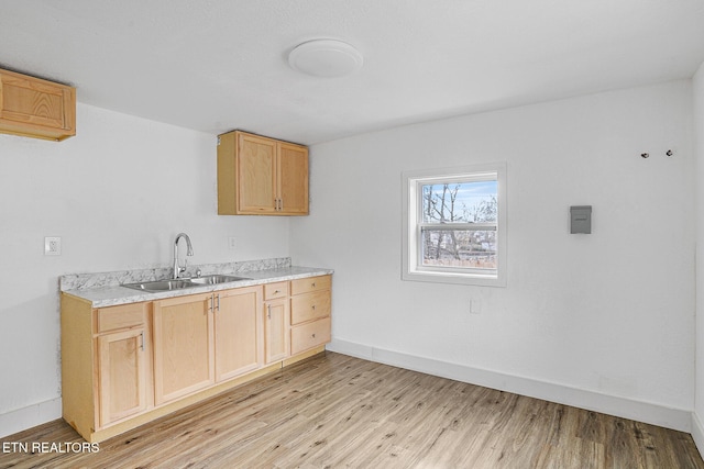 kitchen with sink, light hardwood / wood-style flooring, and light brown cabinets