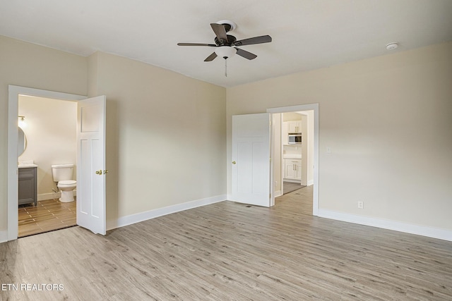 unfurnished bedroom with connected bathroom, ceiling fan, and light wood-type flooring