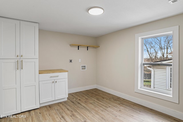 laundry room with hookup for an electric dryer, light hardwood / wood-style floors, cabinets, and washer hookup