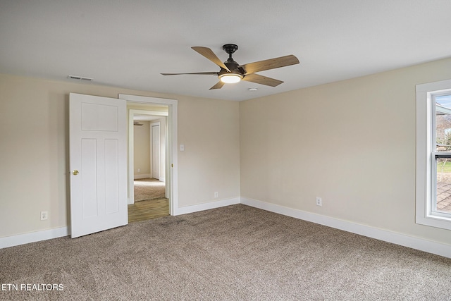 carpeted spare room featuring ceiling fan