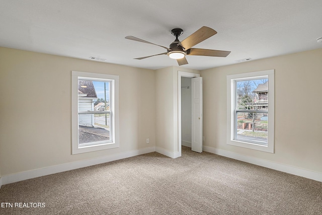 unfurnished bedroom with carpet flooring, ceiling fan, and multiple windows