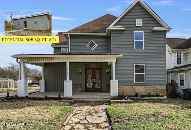 front facade with covered porch, a front yard, and french doors