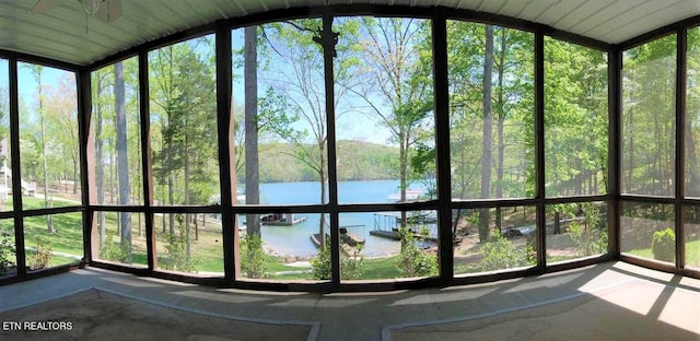 unfurnished sunroom featuring a water view