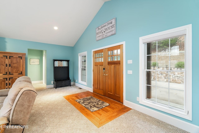 foyer entrance featuring carpet flooring and high vaulted ceiling