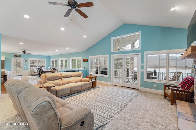 living room featuring ceiling fan, lofted ceiling, and light carpet