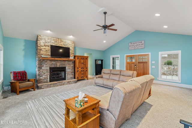 carpeted living room featuring a fireplace, vaulted ceiling, and ceiling fan