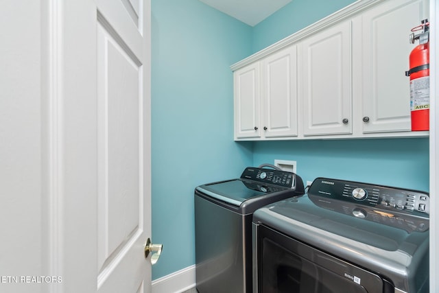 laundry room featuring cabinets and washing machine and dryer