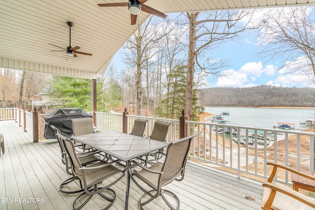 wooden terrace with ceiling fan, a water view, and grilling area