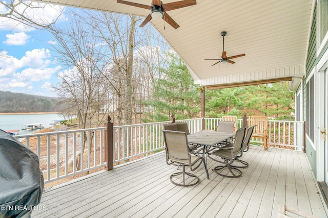 deck with a water view, area for grilling, and ceiling fan