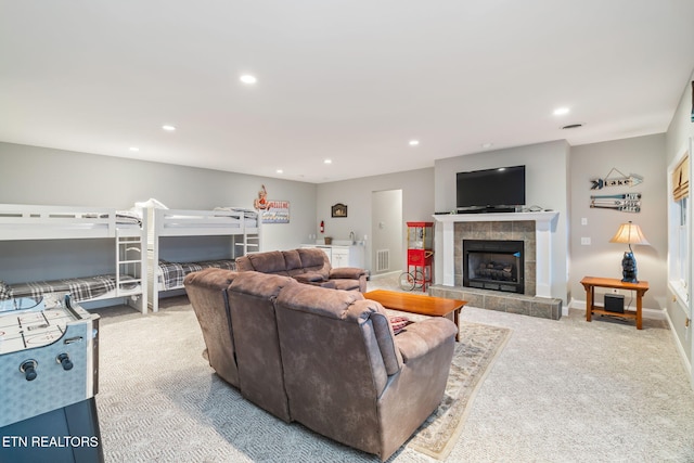 carpeted living room featuring a tile fireplace