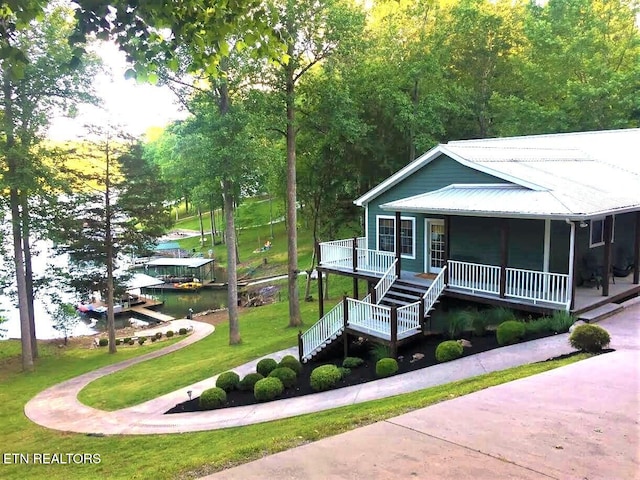 exterior space featuring a porch, a water view, and a yard