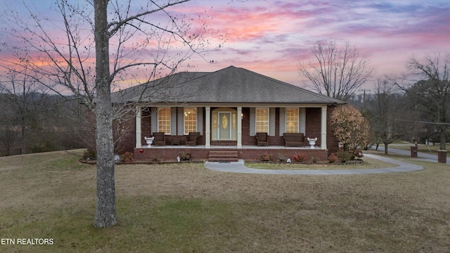 view of front of house featuring a yard and covered porch