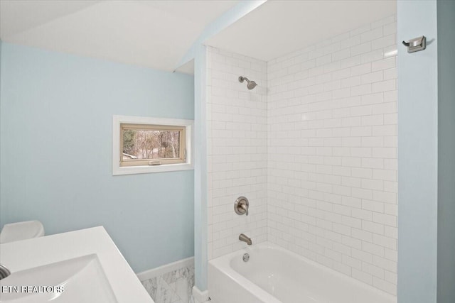 bathroom featuring tiled shower / bath combo and sink