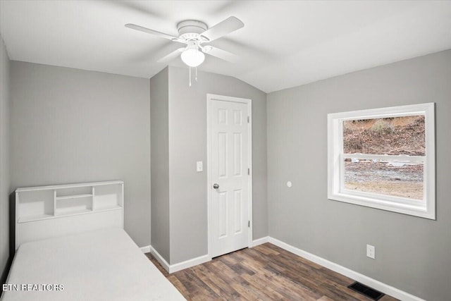 bedroom featuring ceiling fan, dark hardwood / wood-style flooring, and vaulted ceiling